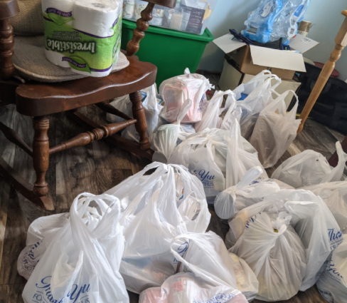 bags from shopping filled with canned and boxed goods for prepping
